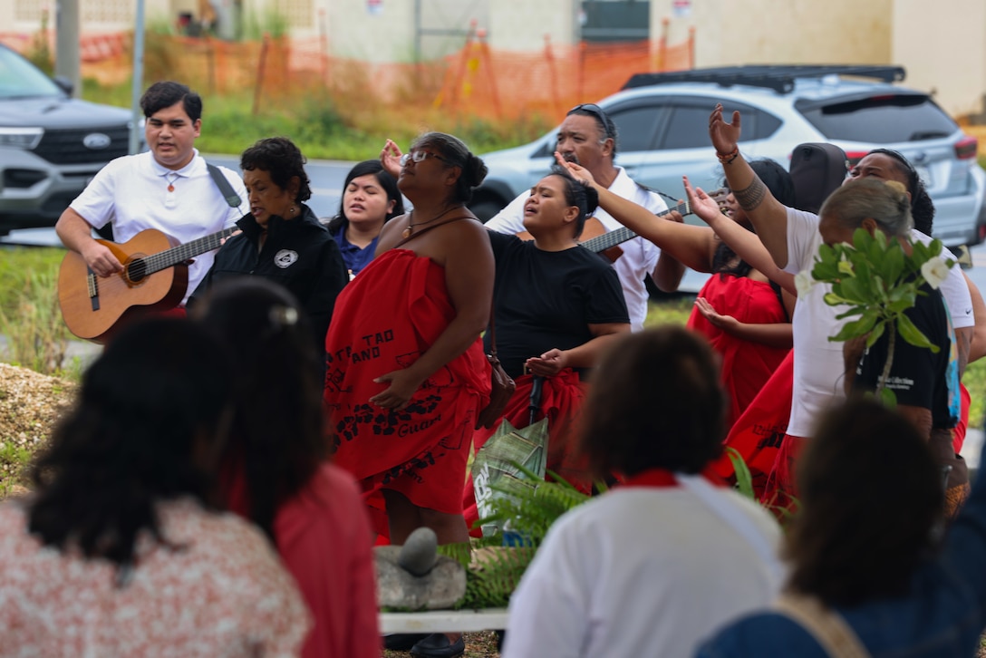 Governor of Guam Lou Leon Guerrero (center) and members of Para I Probechu’n I Taotao-ta, Inc. participate in a CHamoru chant during a burial ritual at a Sabånan Fadang burial site on Marine Corps Base Camp Blaz, Guam, July 27, 2023. The Government of Guam hosted the ritual; Toni ‘Malia’ Ramirez, a cultural representative from the State Historic Preservation Office, blessed the grounds; and Para I Probechu’n I Taotao-ta, Inc. performed a traditional CHamoru chant. “Today was beautiful and I have to thank the military…for the organization, and the people of Guam that are here… the Governor and the Senators and the people that just came to see the [ritual],” Ramirez said. Following the ritual, the guests were invited to pay respects to those buried at the site and visit the other burial sites located in the area. Camp Blaz is still under construction, so for many, this was the first opportunity they’ve had to visit Sabånan Fadang since the discovery of these sites. During the construction of the Blaz main cantonment, five sites each with at least one burial dating to the Latte Period, were discovered. In 2021 a similar ceremony was held at a different Sabånan Fadang site where a monument would later be constructed in 2022. While monuments will not be erected upon all the burial sites, each will be re-covered with native soil and landscaped with indigenous flora. Markers to inform future visitors will be installed as agreed upon between SHPO and Joint Region Marianas. The sites will be opened to the public once construction is completed, and they will be included as part of the Base Access Program. (U.S. Marine Corps photo by Lance Cpl. Garrett Gillespie)