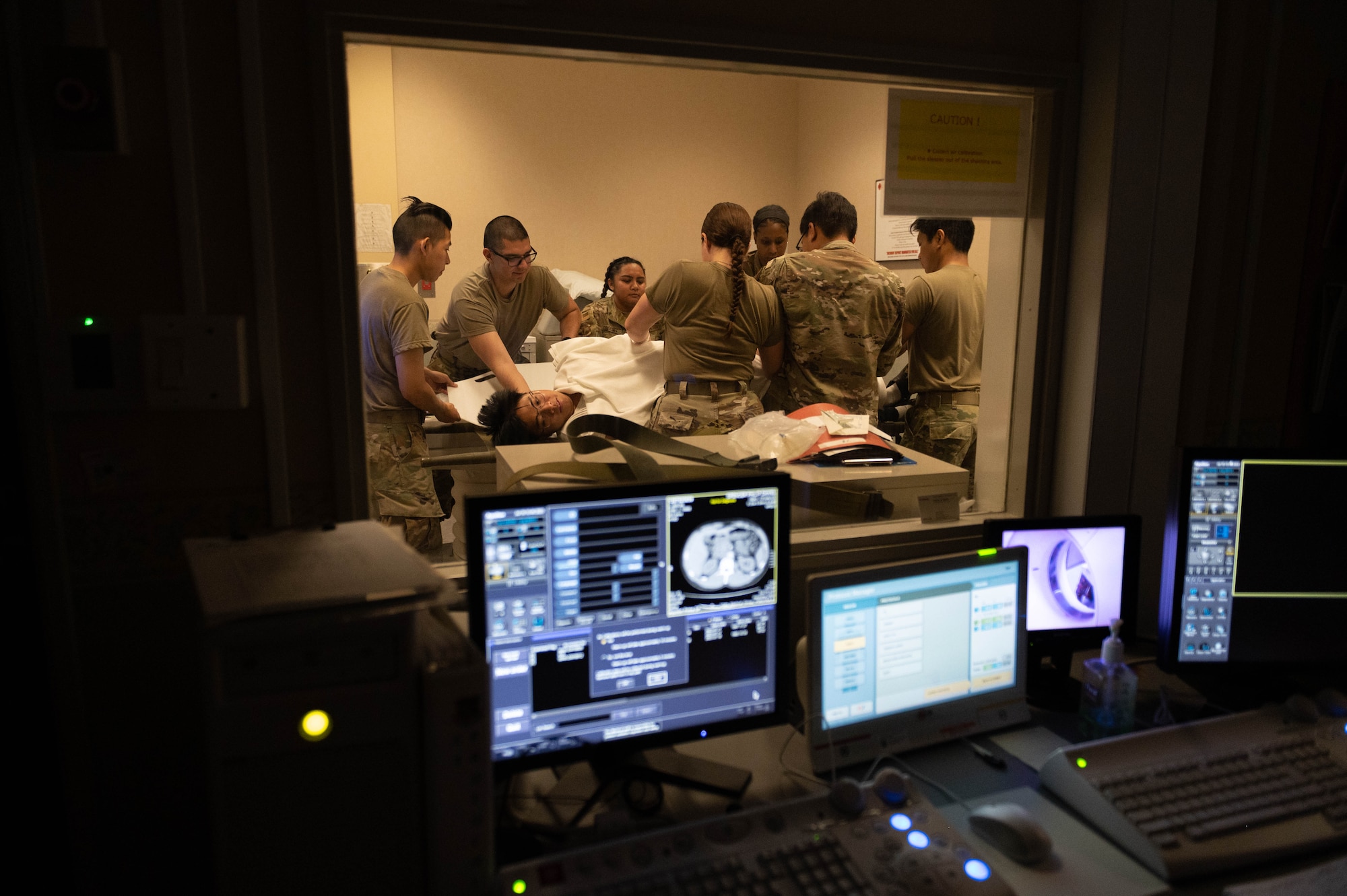 Airmen assigned to the 374th Medical Group move a mock patient onto a litter following a simulated computerized tomography scan.