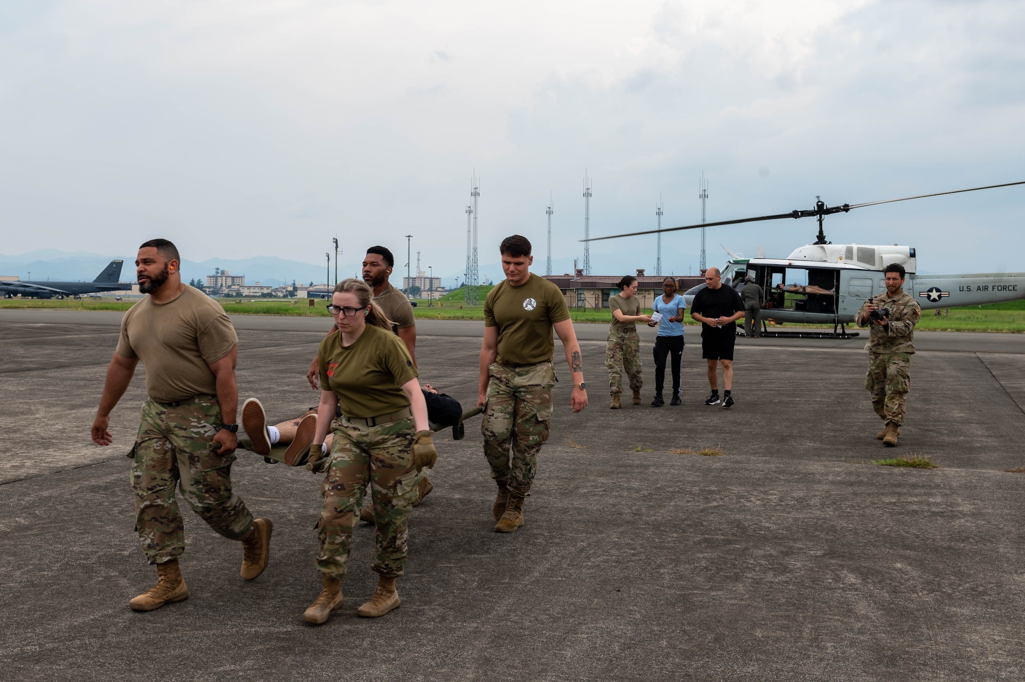 Airmen assigned to the 374th Medical Group transport a mock patient on a litter.