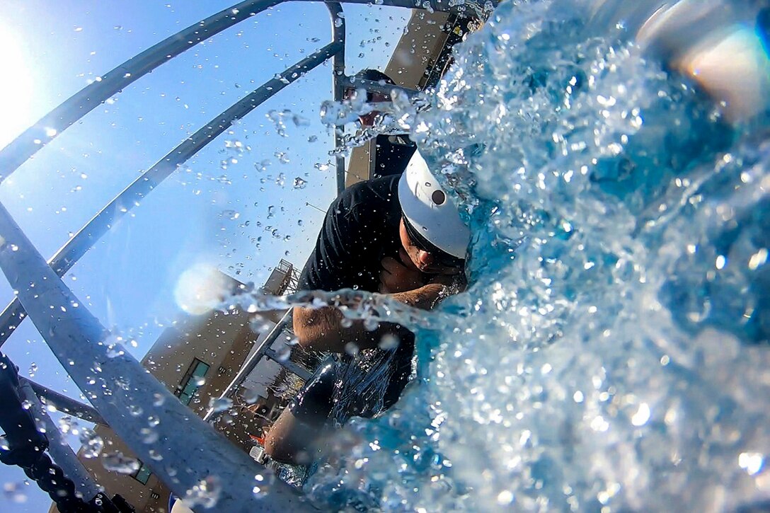 A soldier rolls over in water.