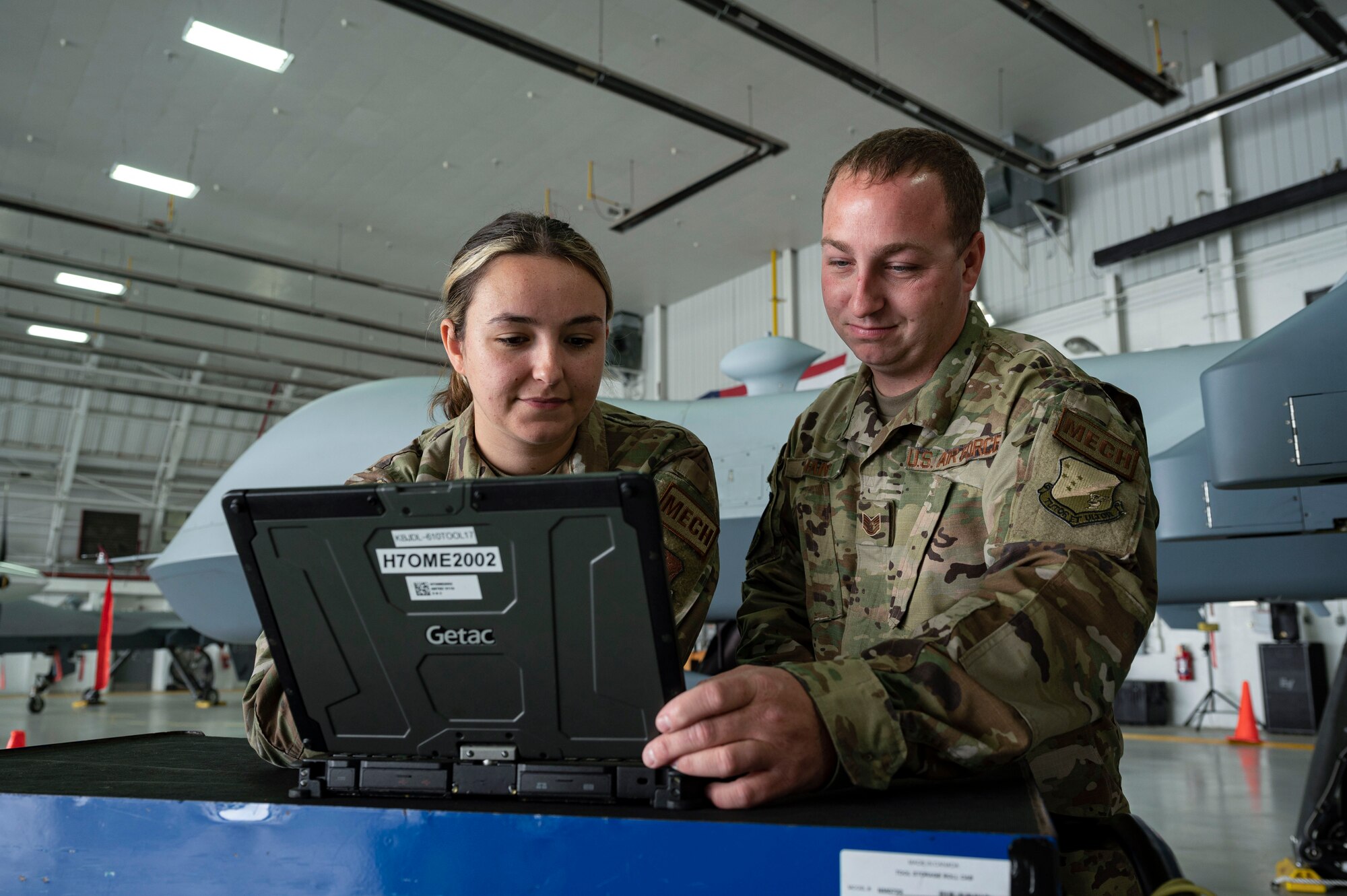U.S. Air Force Senior Airman Morgan Wilson, 174th Attack Wing crew chief, left, and U.S. Air Force Tech. Sgt. Mathew Main, 491st Attack Squadron crew chief, observe the data from an MQ-9 Reaper at Hancock Field Air National Guard Base, New York, June 29, 2023. The 491st ATKS is composed of both active duty and Air National Guard personnel responsible for training student pilots and sensor operators how to operate an MQ-9 Reaper. (U.S. Air Force photo by Airman 1st Class Isaiah Pedrazzini)