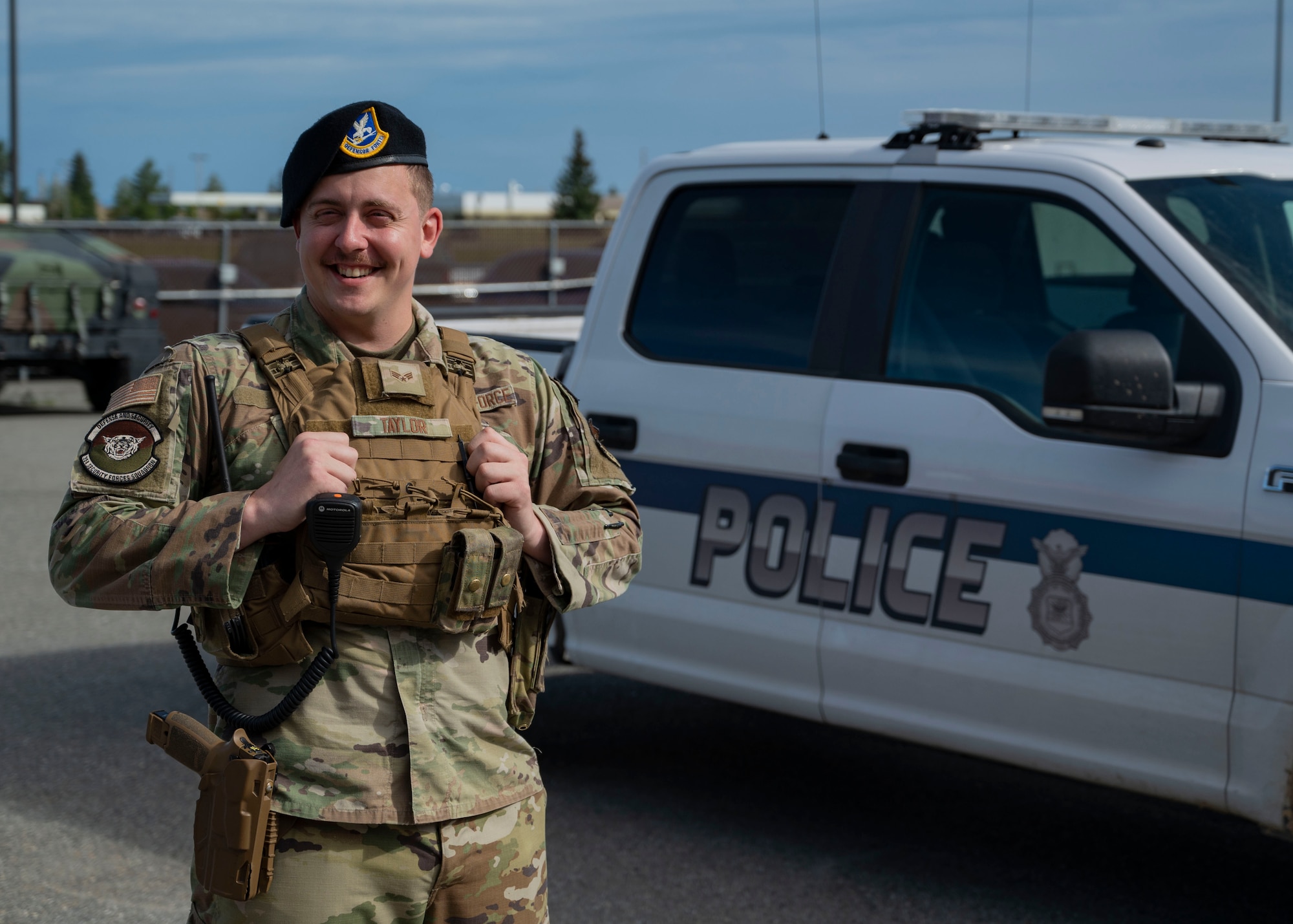 Senior Airman Alan Taylor, a 354th Security Forces Squadron response force leader, stands in front of a police vehicle July 11, 2023, on Eielson Air Force Base, Alaska. Taylor acted as a patrolman during an emergency situation where a family was threatened by an aggressive moose and her calf. (U.S. Air Force photo by Staff Sgt. Beaux Hebert)