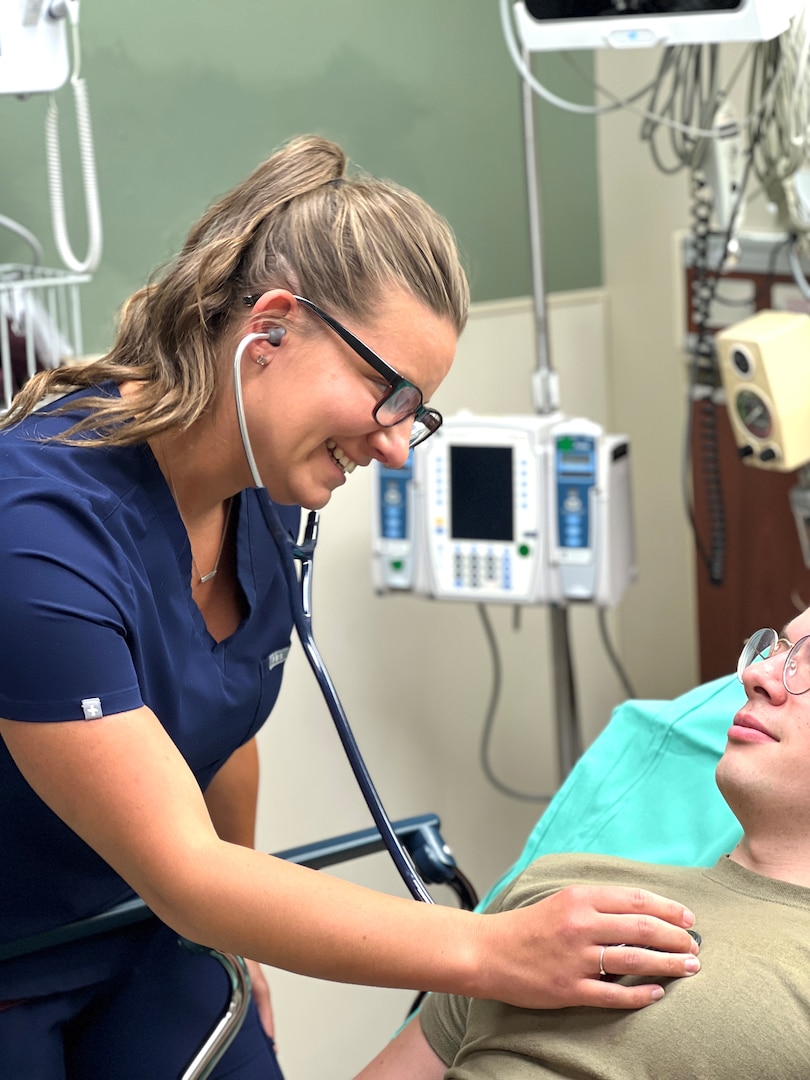 Nurse using a stethoscope to listen to a patient's heart and lungs