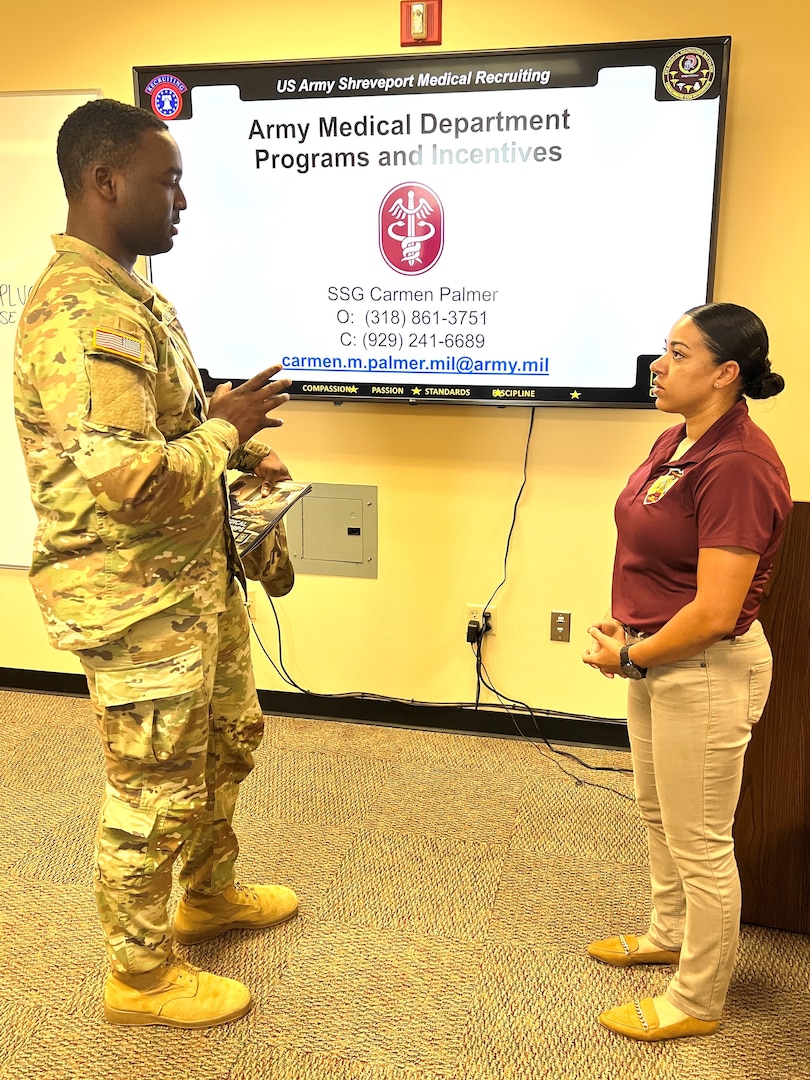 Soldier talking to recruiter in front of a screen projecting a  PowerPoint presentation