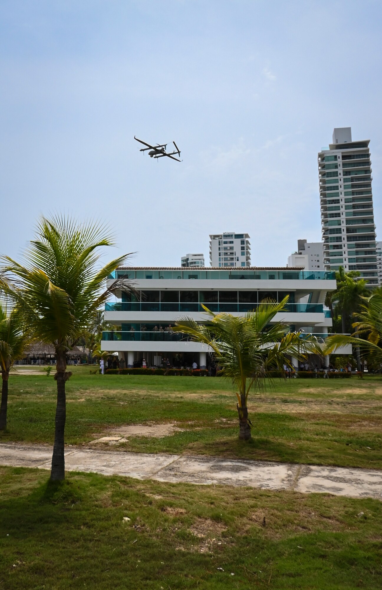 Photos of NITAS members from Colombia and the Republic of Korea discuss the Aerosonde MK4.7 Hybrid Quad unmanned aerial vehicle during demonstration of at the Club Naval Castillogrande during UNITAS LXIV, July 16, 2023.