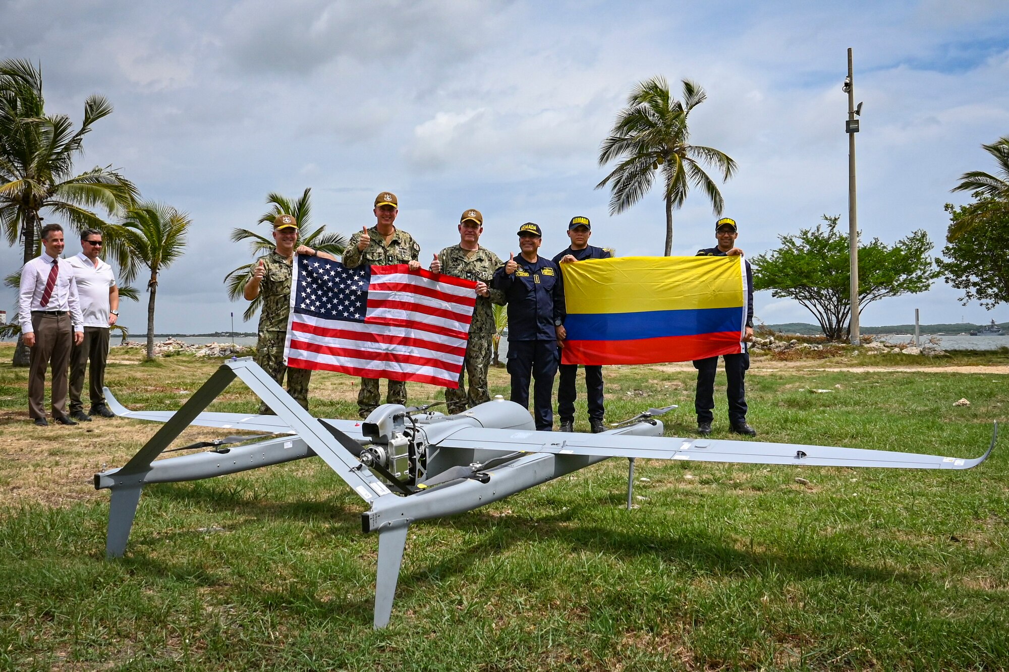 Photos of NITAS members from Colombia and the Republic of Korea discuss the Aerosonde MK4.7 Hybrid Quad unmanned aerial vehicle during demonstration of at the Club Naval Castillogrande during UNITAS LXIV, July 16, 2023.