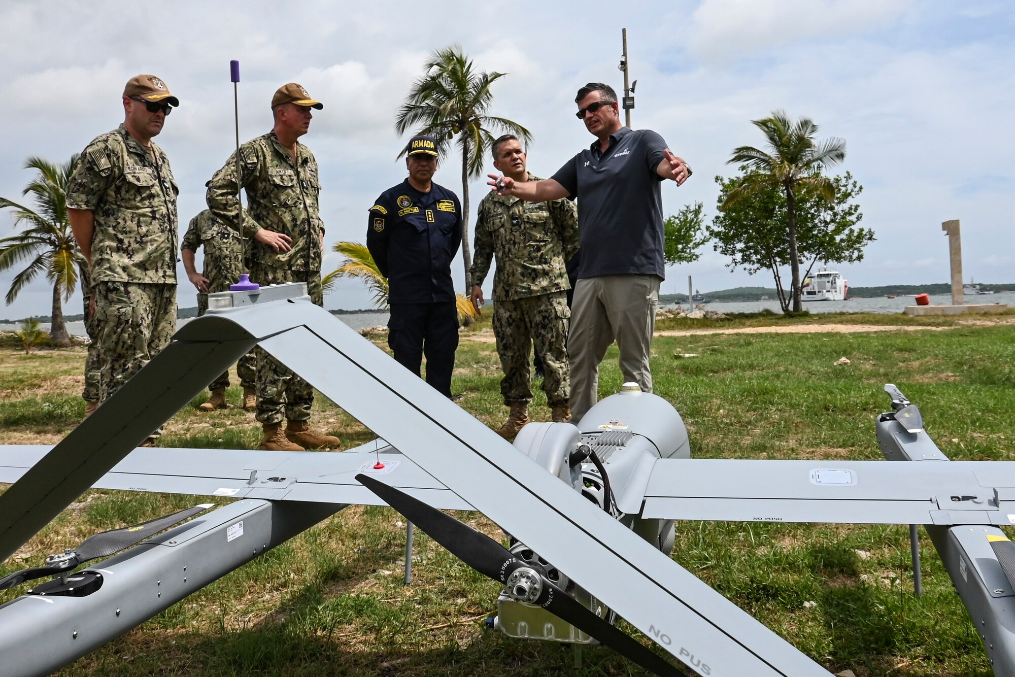 Photos of NITAS members from Colombia and the Republic of Korea discuss the Aerosonde MK4.7 Hybrid Quad unmanned aerial vehicle during demonstration of at the Club Naval Castillogrande during UNITAS LXIV, July 16, 2023.
