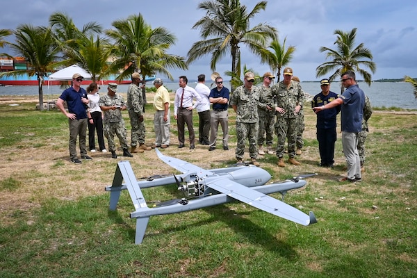 Photos of NITAS members from Colombia and the Republic of Korea discuss the Aerosonde MK4.7 Hybrid Quad unmanned aerial vehicle during demonstration of at the Club Naval Castillogrande during UNITAS LXIV, July 16, 2023.