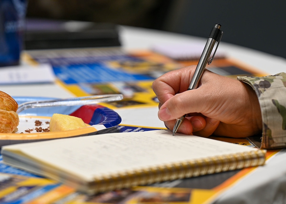 A Senior Leader Summit attendee takes notes at the Powel Event Center, Goodfellow Air Force Base, Texas, July 26, 2023. The summit showcased Goodfellow's unwavering commitment to training personnel from all branches within the Department of Defense and allied nations. (U.S. Air Force Photo by Airman 1st Class Zach Heimbuch)