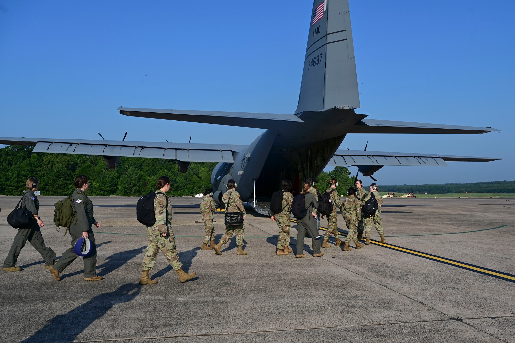 Service members walk toward a C-130.