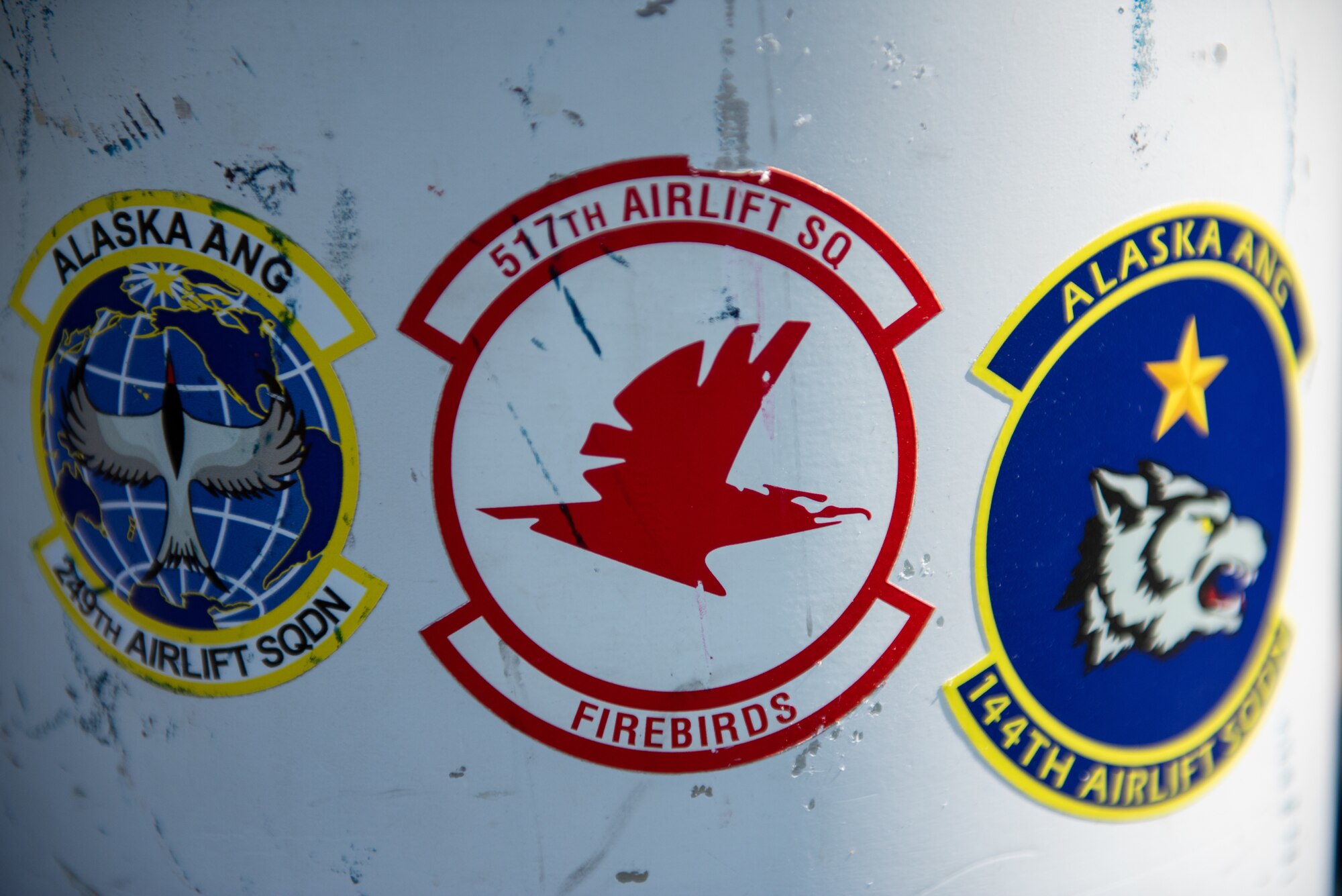 Squadron stickers for the Alaska Air National Guard’s 249th Airlift Squadron and 144th Airlift Squadron, and the U.S. Air Force 517th Airlift Squadron decorate a bell at the crash site of “Sitka 43” during a final roll call memorial ceremony and a toast at Joint Base Elmendorf-Richardson, Alaska.