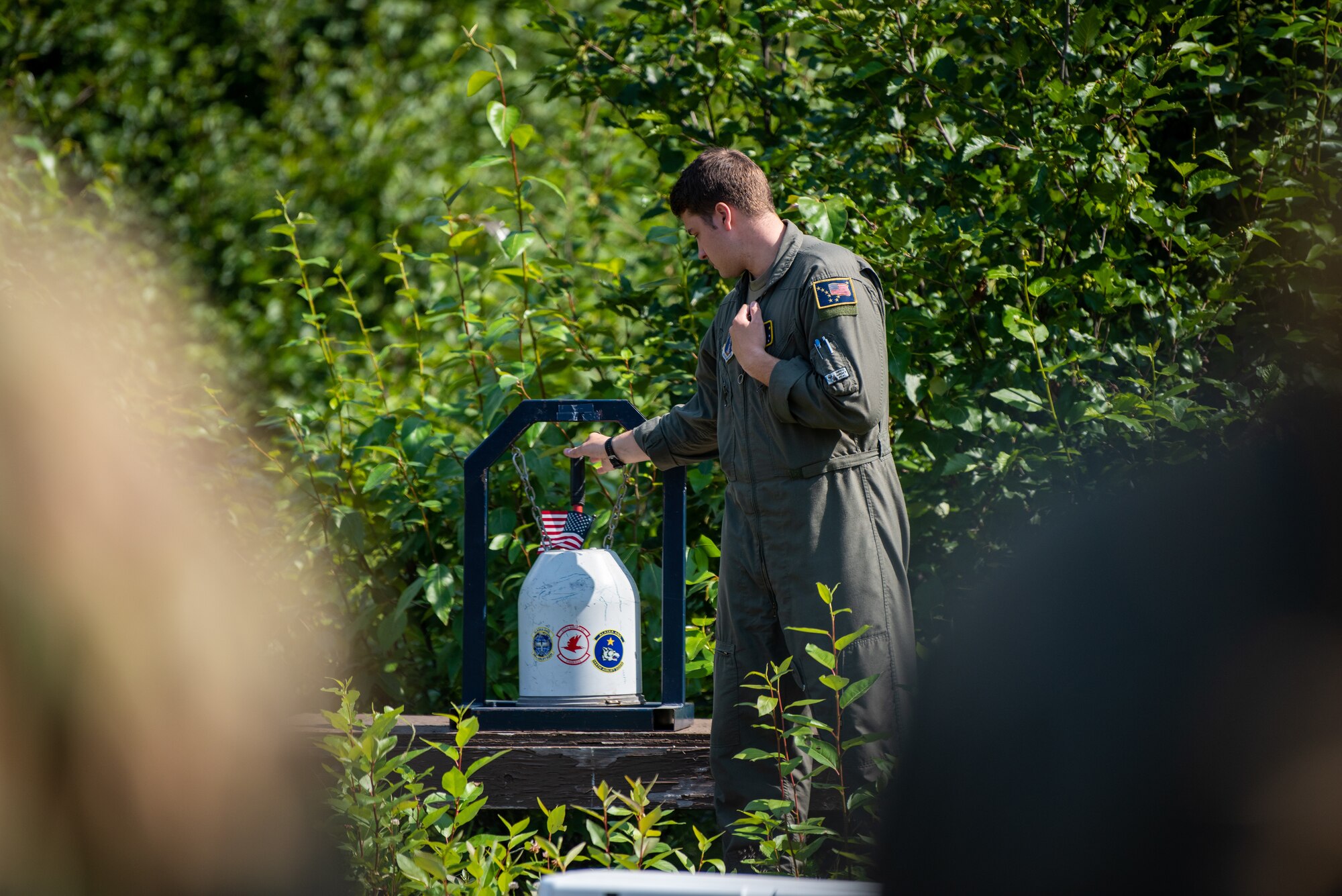 An Alaska Air National Guardsman rings a bell during a final roll call for the fallen service members at the crash site of “Sitka 43” at Joint Base Elmendorf-Richardson.