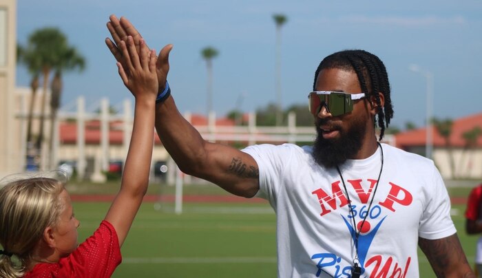 coach high-fives a young girl