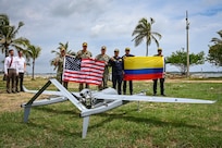 Photos of NITAS members from Colombia and the Republic of Korea discuss the Aerosonde MK4.7 Hybrid Quad unmanned aerial vehicle during demonstration of at the Club Naval Castillogrande during UNITAS LXIV, July 16, 2023.