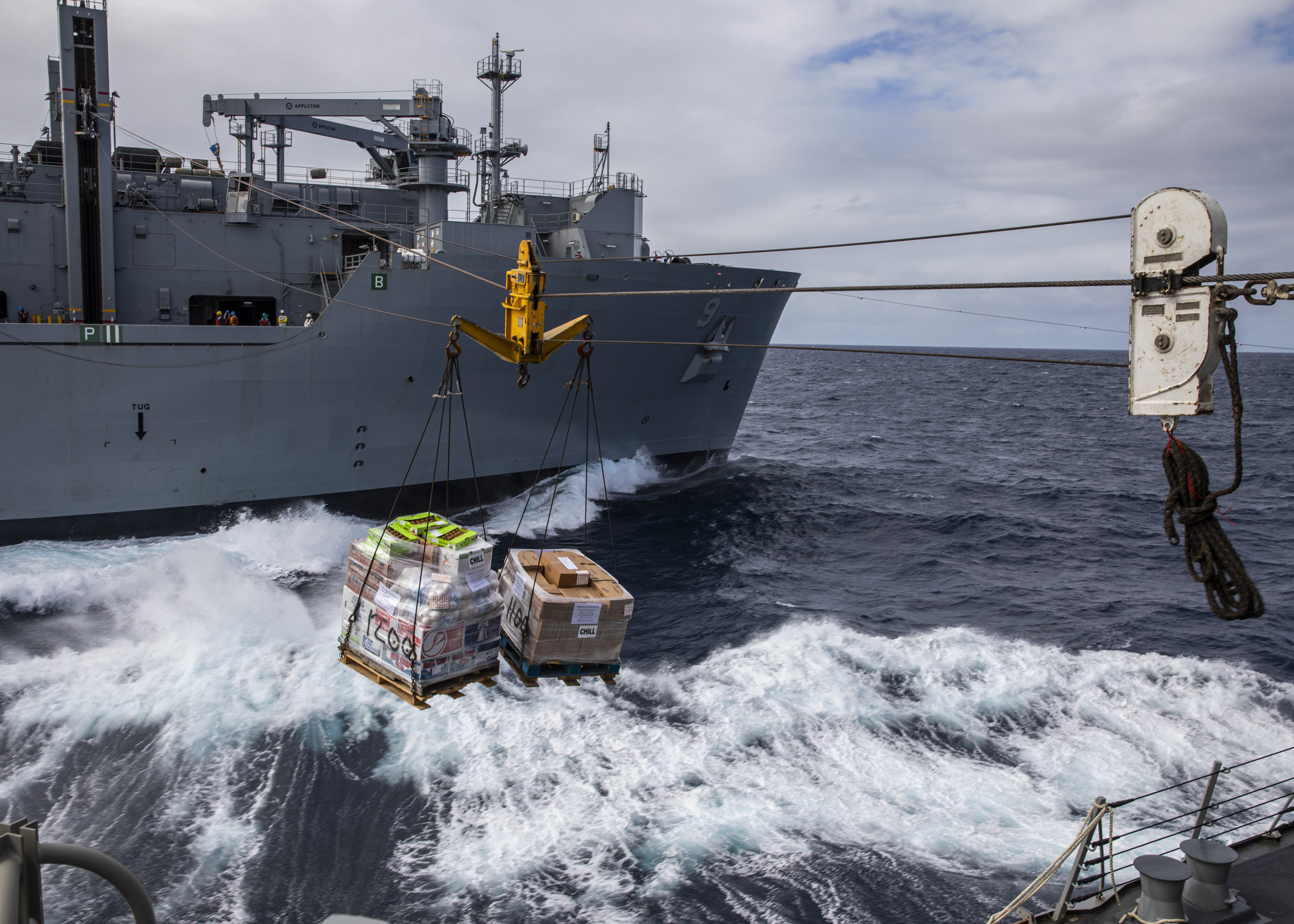 USS Rafael Peralta (DDG 115) receives cargo during a replenishment-at-sea with the Military Sealift Command fleet replenishment oiler USNS Matthew Perry (T-AKE 9) in the Coral Sea.