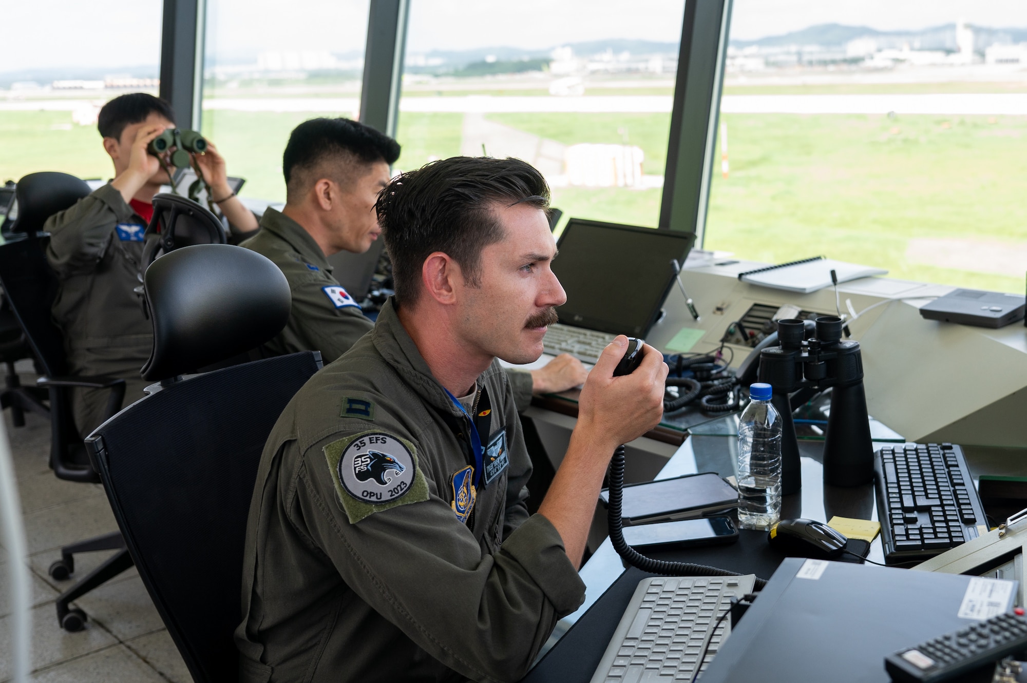 U.S. Air Force Capt. Tyler Hansen, Republic of Korea Air Force Lt. Col. Young Jun Kim and ROKAF Capt. Micheol Rho man the operations tower during a U.S.-ROK buddy squadron