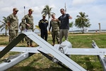 Photos of NITAS members from Colombia and the Republic of Korea discuss the Aerosonde MK4.7 Hybrid Quad unmanned aerial vehicle during demonstration of at the Club Naval Castillogrande during UNITAS LXIV, July 16, 2023.