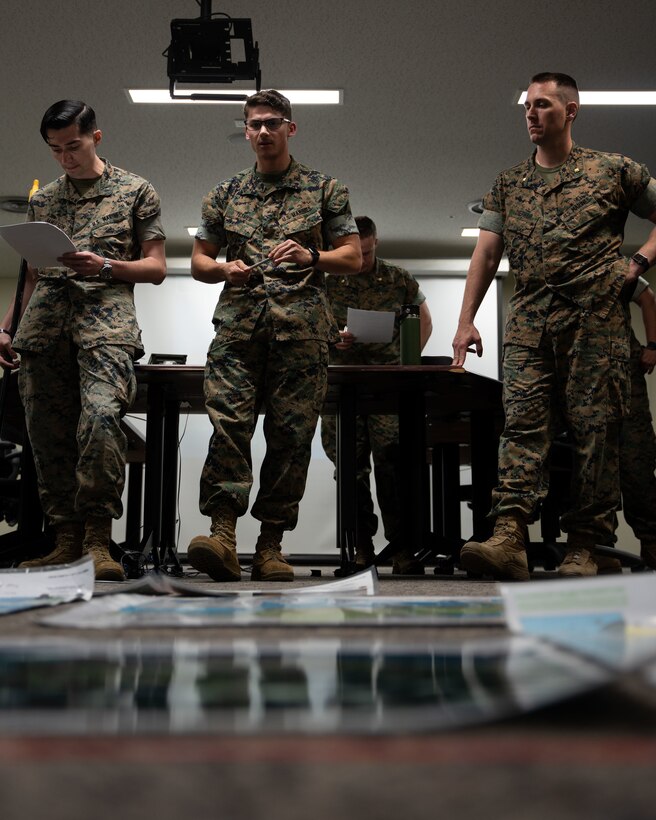 U.S. Marine Corps Cpl. Ethan Tesmer (center), embarkation chief for Combat Logistics Battalion 4, briefs projected day-to-day operations for embarkation during a rehearsal of concepts brief in preparation for an upcoming Marine Corps Combat Readiness Evaluation at Camp Schwab, Apr. 21, 2023. A ROC “walk” is the last step in the planning process for an exercise or operation where commanders and relevant military personnel go over every detail of the exercise or operation to ensure every participant knows their role to achieve mission success. (U.S. Marine Corps photo by Cpl. Madison Santamaria)