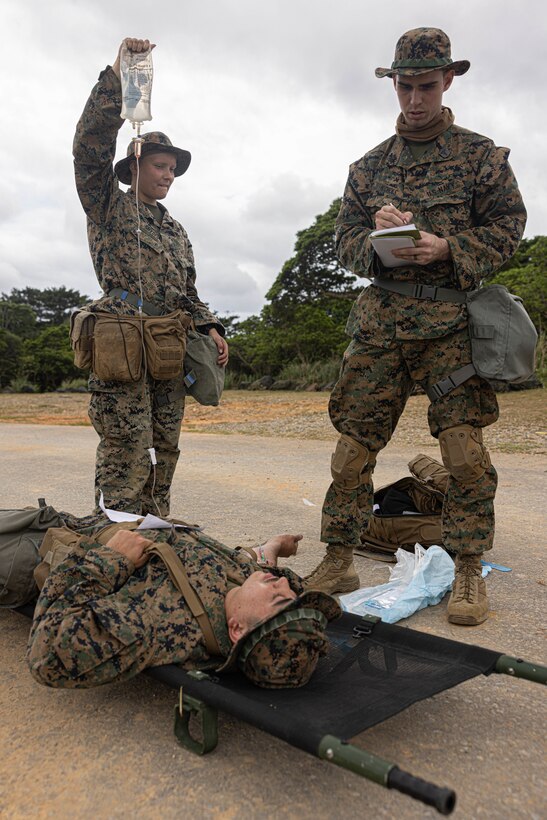 U.S. Marines and Sailors from 3rd Marine Logistics Group treat a simulated casualty for a mass casualty drill during a Marine Corps Combat Readiness Evaluation at Camp Hansen, Okinawa, Japan, April 26, 2023. 3rd Marine Logistics Group, based out of Okinawa, Japan, is a forward-deployed combat unit that serves as III MEF’s comprehensive logistics and combat service support backbone for operations throughout the Indo-Pacific area of responsibility. (Marine Corps photo by Lance Cpl. Weston Brown)