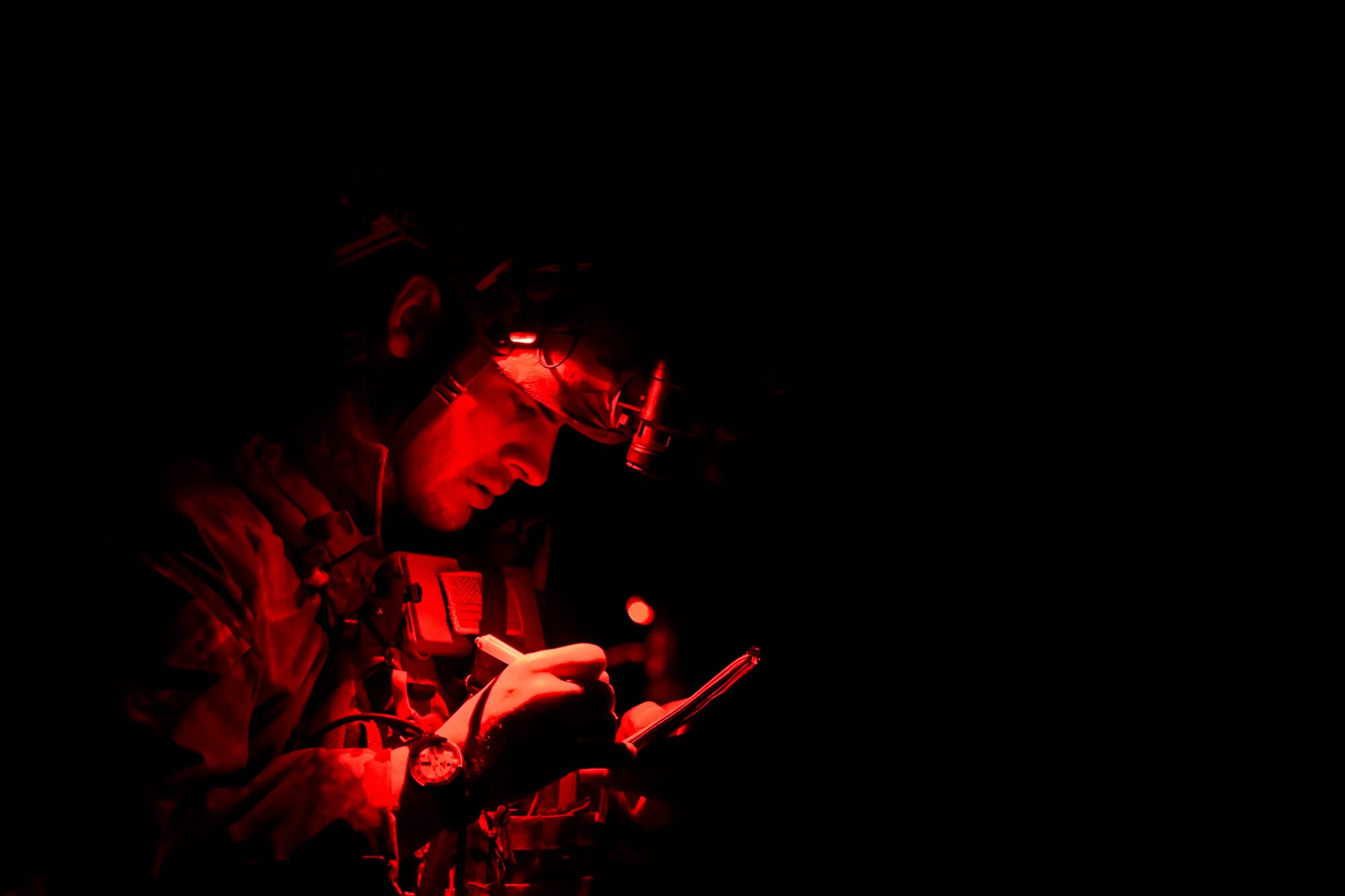 A U.S. Air Force pararescueman from the 57th Rescue Squadron annotates notes at a simulated helicopter crash during exercise Astral Knight 2023 in the Albanian countryside May 23, 2023. Exercises like AK23 support NATO Allies and partner nations operational readiness and strengthens partnerships, crisis response efforts and deter threats. (U.S. Air Force photo by Senior Airman Noah Sudolcan)