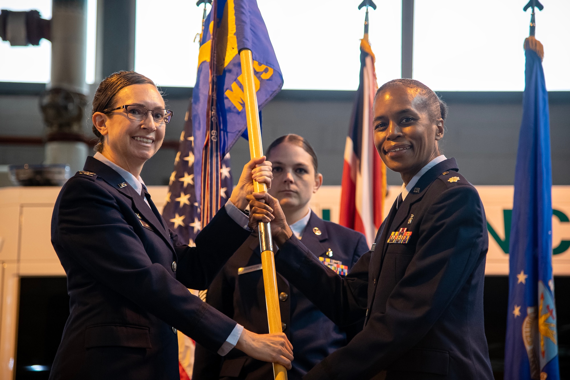U.S. Air Force Lt. Col. Yvonne Storey, 423d Medical Squadron incoming commander, right, receives the 423d MDS guidon from Col. Valerie Long, 423d Air Base Group commander during a change of command ceremony at RAF Alconbury, England, May 30, 2023. Prior to assuming command, Storey served as the Chief Nurse executive for the 412th Medical Group, Edwards Air Force Base, Calif. (U.S. Air Force photo by Staff Sgt. Eugene Oliver)
