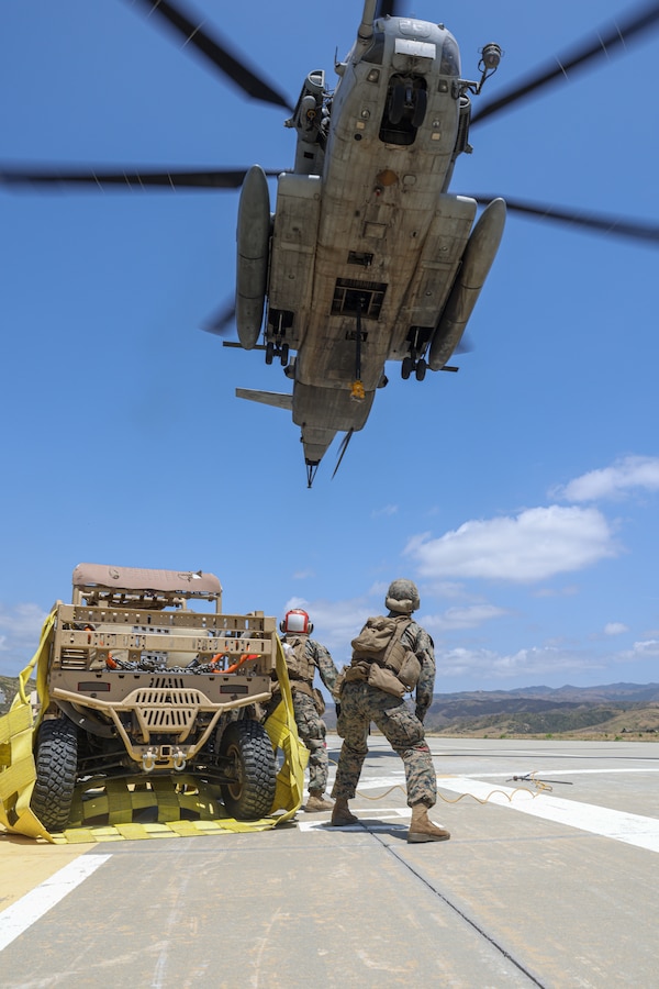 U.S. Marines assigned to Combat Logistics Battalion 15, Combat Logistics Regiment 17, 1st Marine Logistics Group, prepare to hook a Polaris MRZR, an ultra-light turbo diesel combat vehicle, beneath a CH-53E Super Stallion attached to Marine Heavy Helicopter Squadron (HMH) 361, Marine Aircraft Group 16, 3rd Marine Aircraft Wing, during external lift operations at Marine Corps Base Camp Pendleton, California, May 9, 2023. CLB-15 and HMH-361 worked together to test an innovative lift method utilizing wheel nets to inform publication and standard operating procedure development for the Marine Corps. (U.S. Marine Corps photo by Cpl. Hekker)