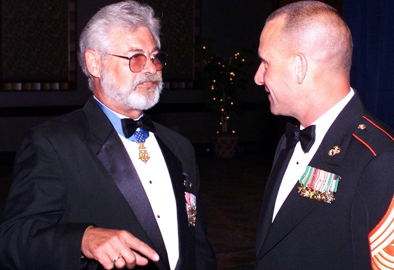 Two men in uniform talk.