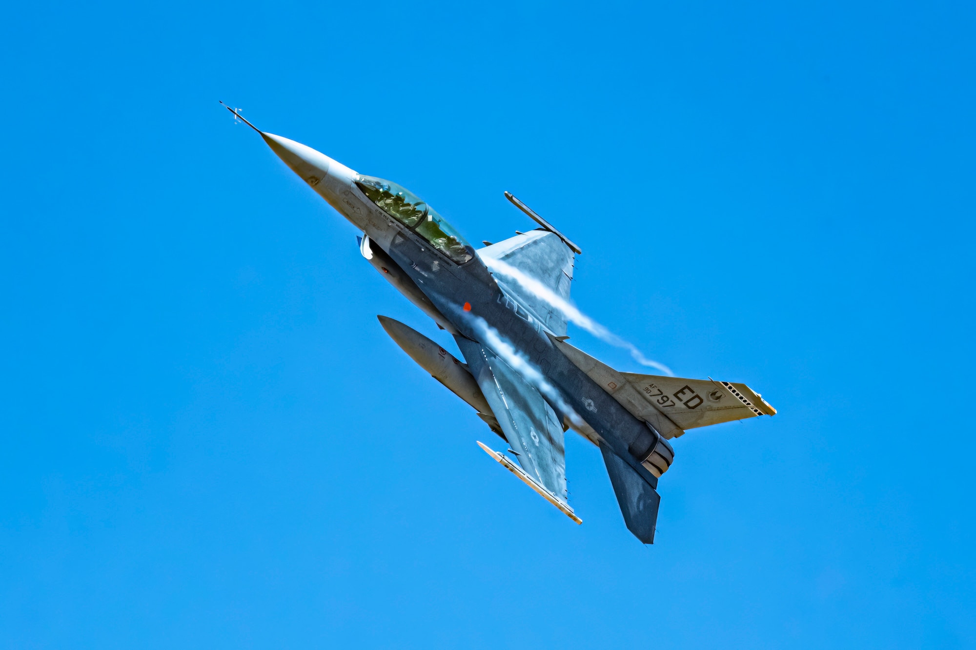 An F-16D Fighting Falcon flies over the Precision Impact Range Area on Edwards Air Force Base, California, May 10. As part of the U.S. Air Force Test Pilot School Space Test Course Class 23-1 capstone project, the F-16 dropped munitions onto the PIRA and used satellite imagery to conduct battle damage assessment. (Air Force photo by Giancarlo Casem)