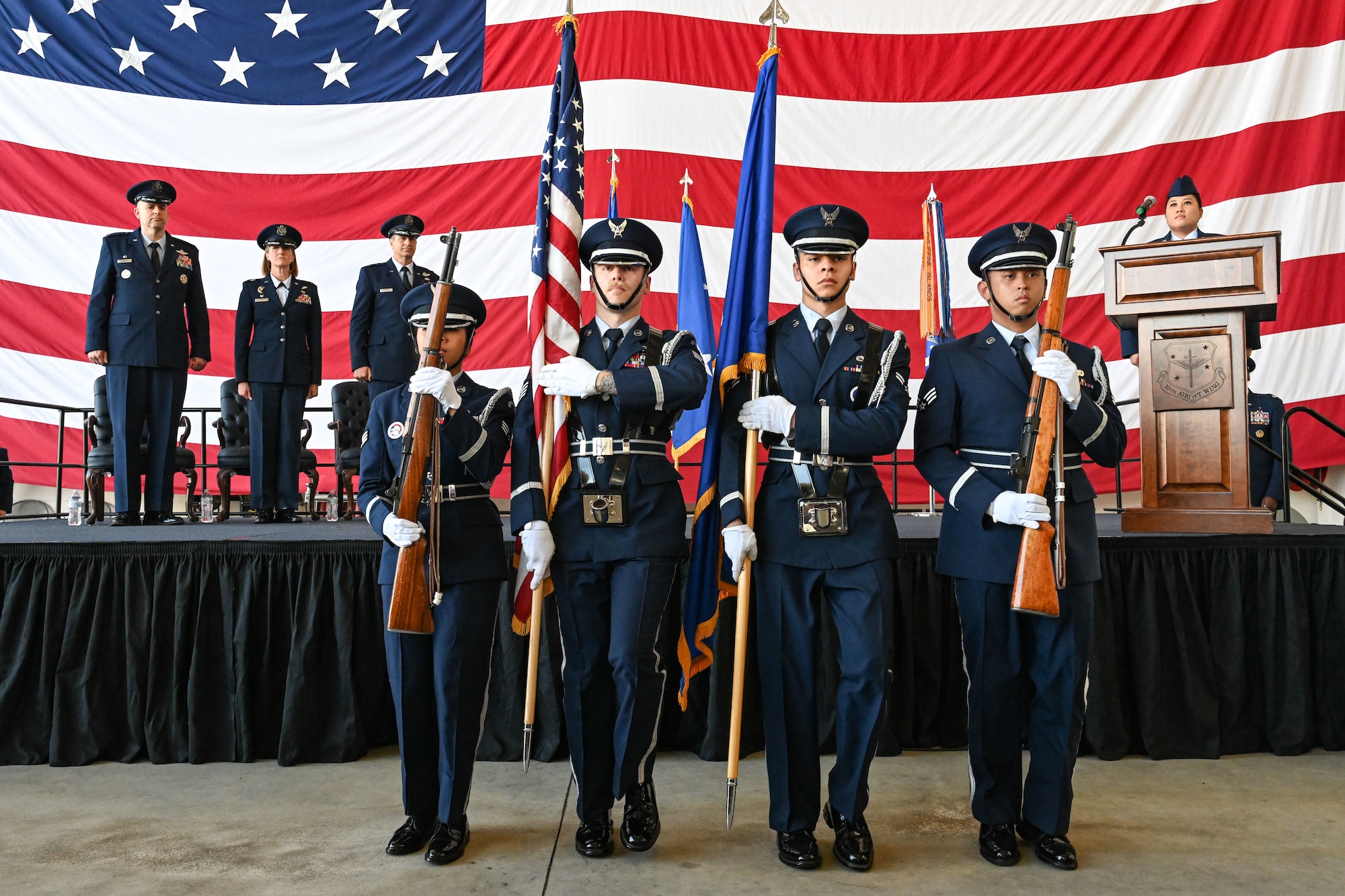 Airmen from the 19th Airlift Wing participate in a change of command ceremony in an airplane hangar