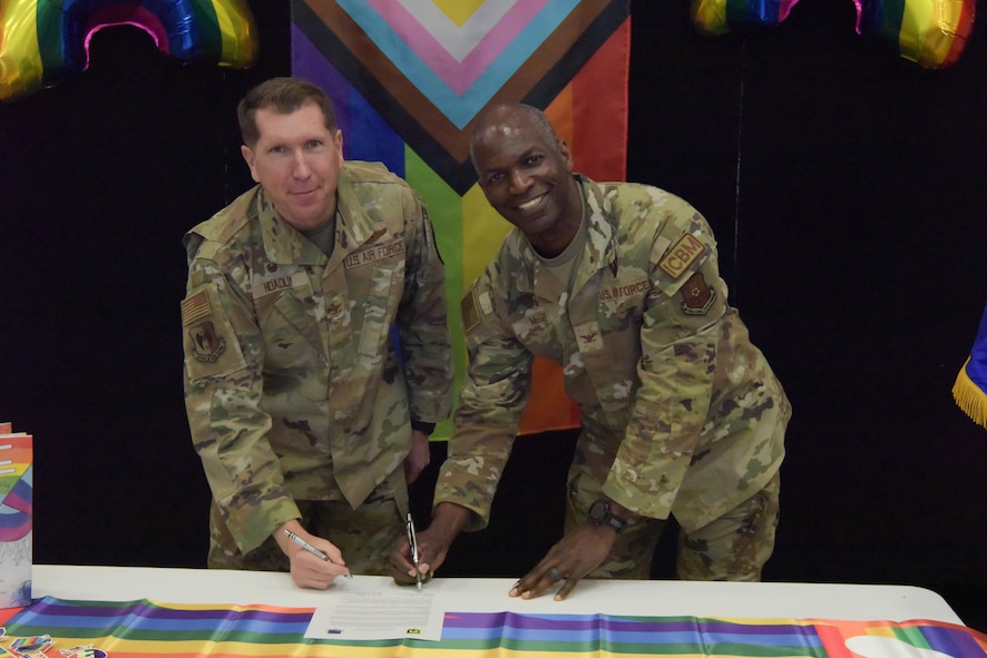 Team Minot Airmen pose for a group photo with Col. Daniel Hoadley, 5th Bomb Wing commander, and Col. Kenneth McGhee, 91st Missile Wing commander, at the LGBTQI+ Pride Month opening ceremony at Minot Air Force Base, North Dakota, June 1, 2023. LGBTQI+ Pride Month is celebrated annually in June to honor members of the LGBTQI+ community. (U.S. Air Force photo by Airman 1st Class Kyle Wilson)