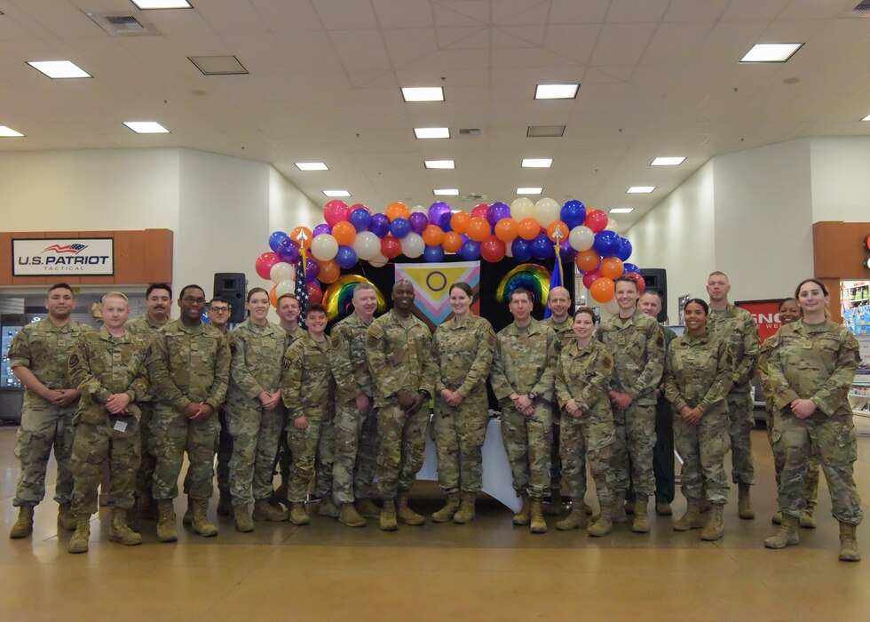 Team Minot Airmen pose for a group photo with Col. Daniel Hoadley, 5th Bomb Wing commander, and Col. Kenneth McGhee, 91st Missile Wing commander, at the LGBTQI+ Pride Month opening ceremony at Minot Air Force Base, North Dakota, June 1, 2023. LGBTQI+ Pride Month is celebrated annually in June to honor members of the LGBTQI+ community. (U.S. Air Force photo by Airman 1st Class Kyle Wilson)