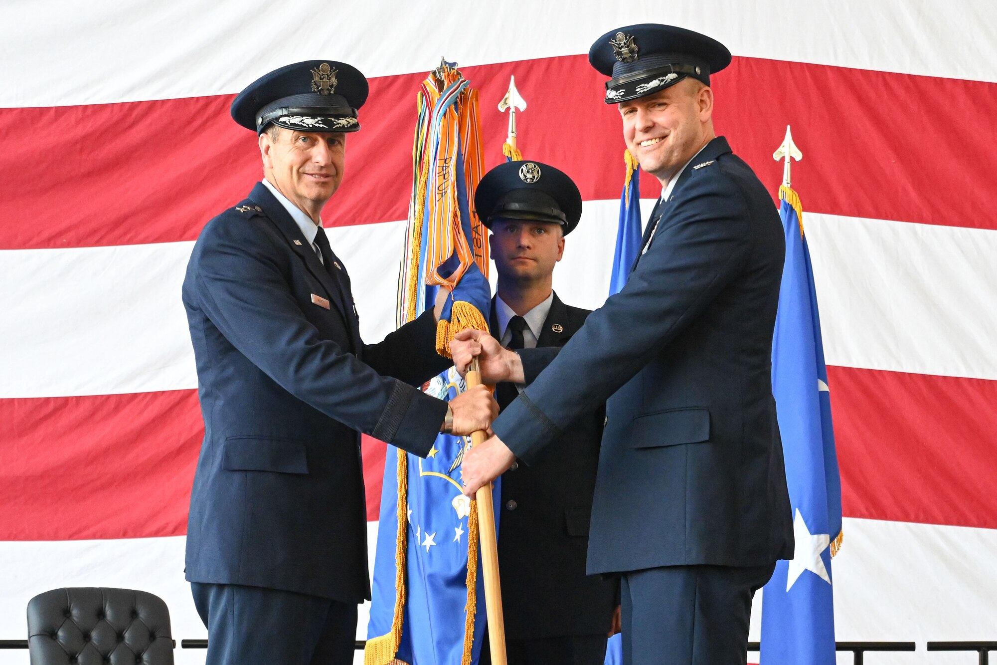 Airmen from the 19th Airlift Wing participate in a change of command ceremony in an airplane hangar