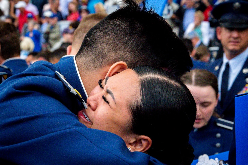An Air Force cadet shares a hug in a crowd.