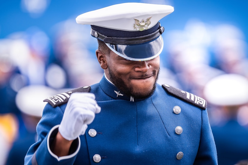 A cadet smiles and pumps a fist.