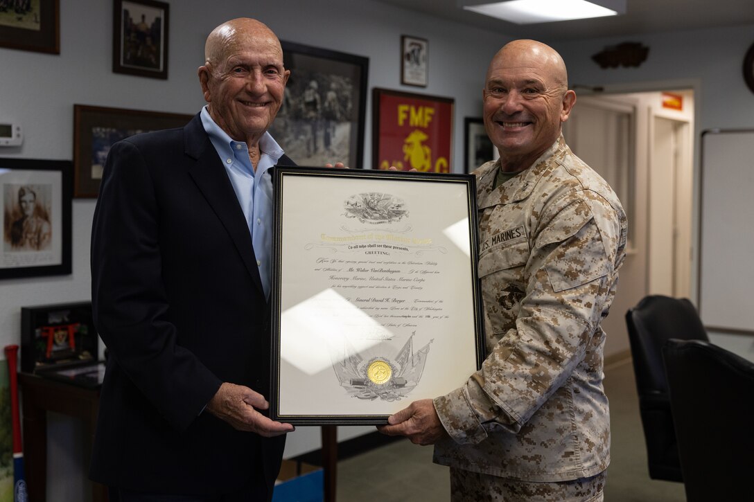 U.S. Marine Corps Maj. Gen. Austin Renforth presents Walter Vanbenthuysen with an "Honorary Marine" certificate