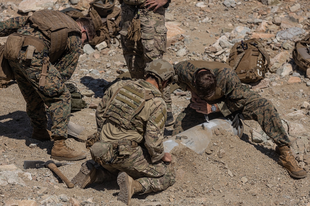 U.S. service members with the Explosive Ordnance Disposal (EOD) Advanced Training Center clean a controlled explosive