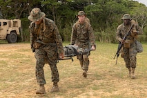 U.S. Marines and Sailors across 3rd Marine Logistics Group escort a simulated casualty to safety for a mass casualty drill during a Marine Corps Combat Readiness Evaluation at Camp Hansen, Okinawa, Japan, April 26, 2023. 3rd Marine Logistics Group, based out of Okinawa, Japan, is a forward-deployed combat unit that serves as III MEF’s comprehensive logistics and combat service support backbone for operations throughout the Indo-Pacific area of responsibility. (Marine Corps photo by Lance Cpl. Weston Brown)
