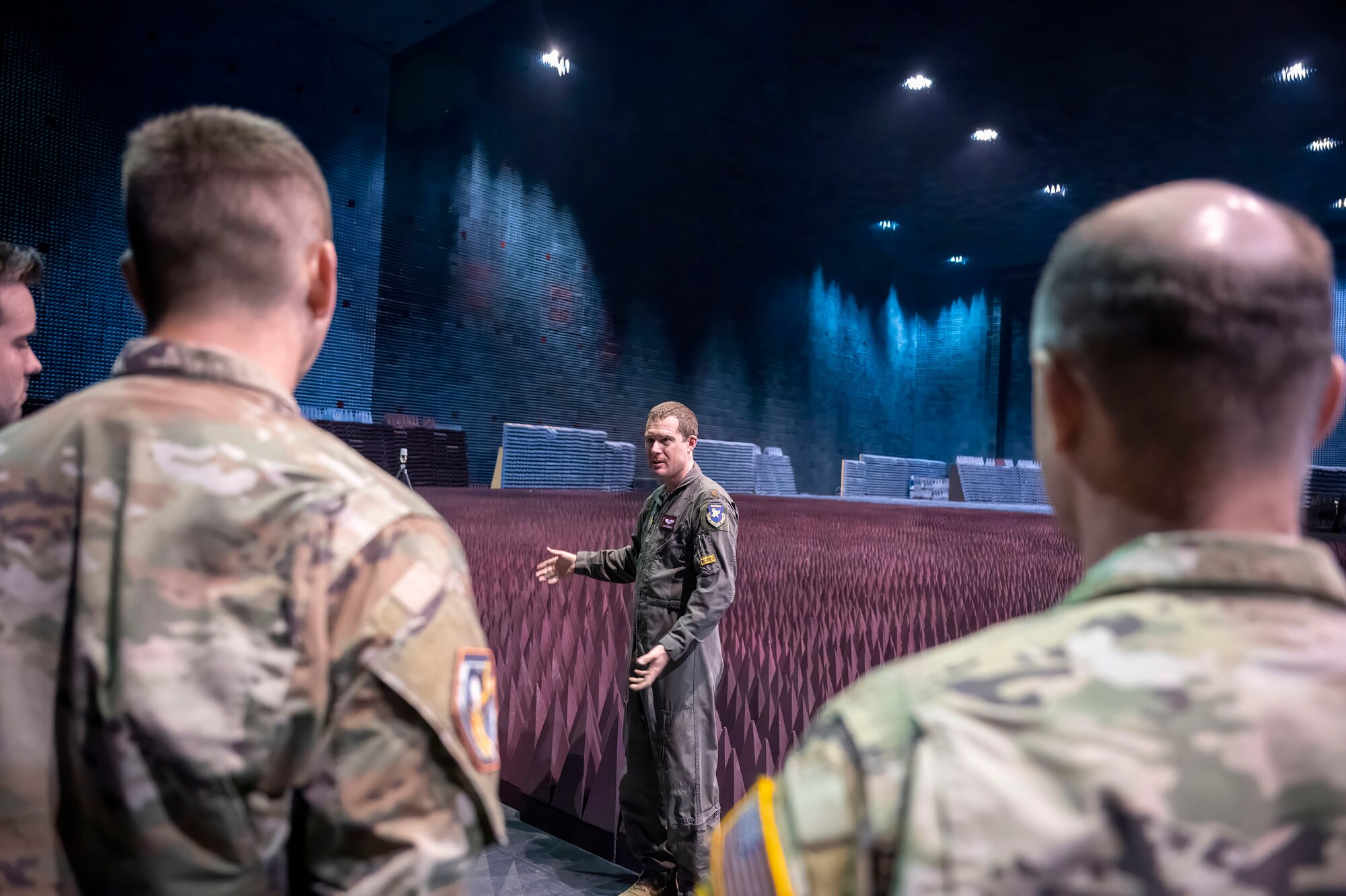 Air Force Maj. Phillip Woodhull, 772nd Test Squadron Director of Operations, provides a brief of the Benefield Anechoic Facility to Test Pilot School Space Test Course Class 23-1 students on Edwards Air Force Base, California, May 22. The STC students saw a Navigation Technology Satellite-3 (NTS-3) up close during its test campaign inside the BAF. (Air Force photo by Adam Bowles)