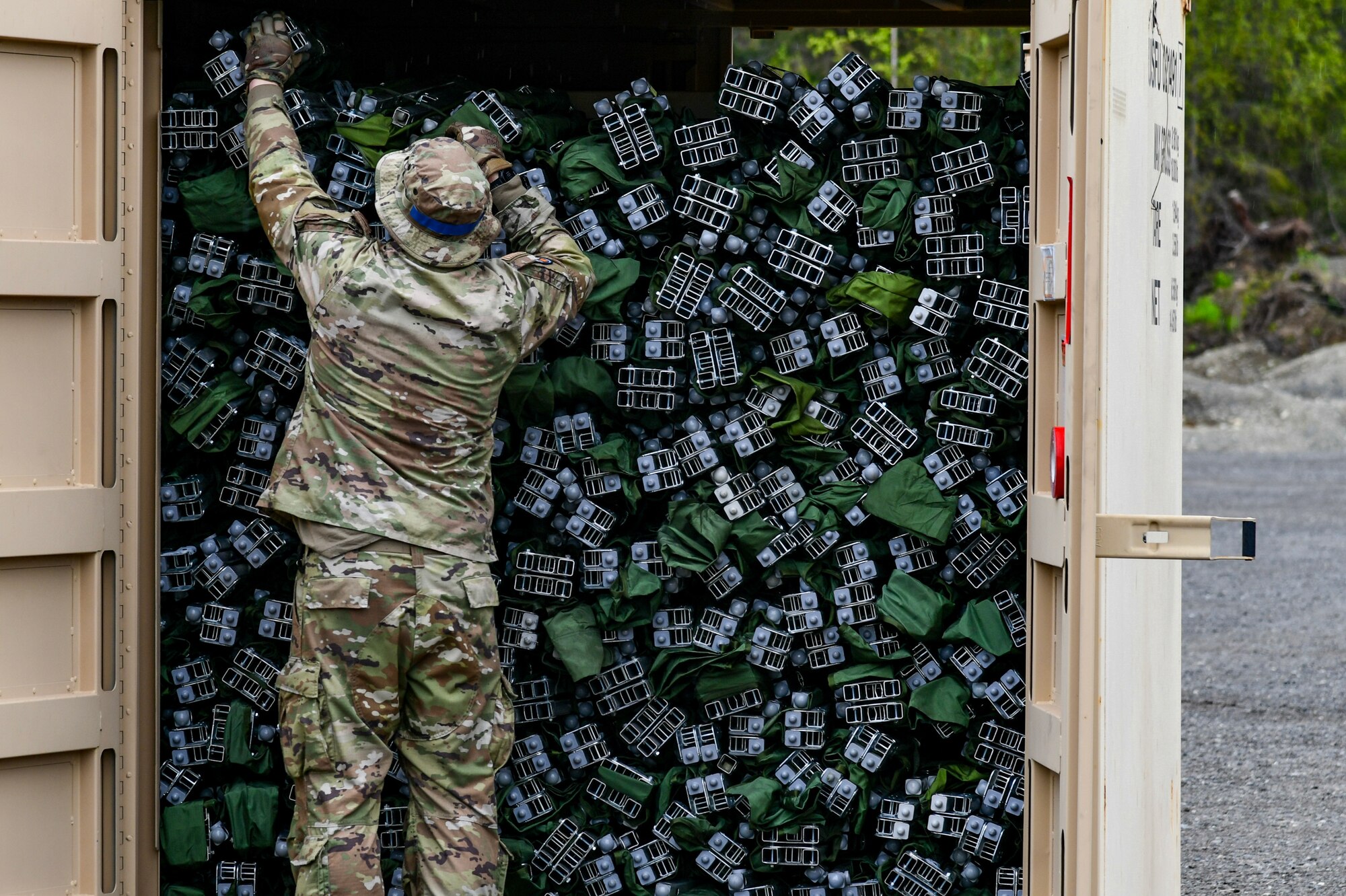 A photo of U.S. Air Force Maj. Alex Siedel, 111th Civil Engineer Squadron officer, packing away United States General Issue Military Tri-folding Cots into a Conex box to conclude Scruffy Devil.