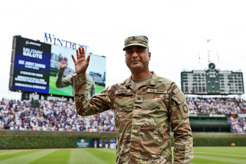 U.S. Army Reserve Sgt. Amrit Sandhu, assigned to the 85th U.S. Army Reserve Support Command, Arlington Heights, Illinois, waves to spectators during a Chicago Cubs Military Salute home game on Memorial Day, May 29, 2023.