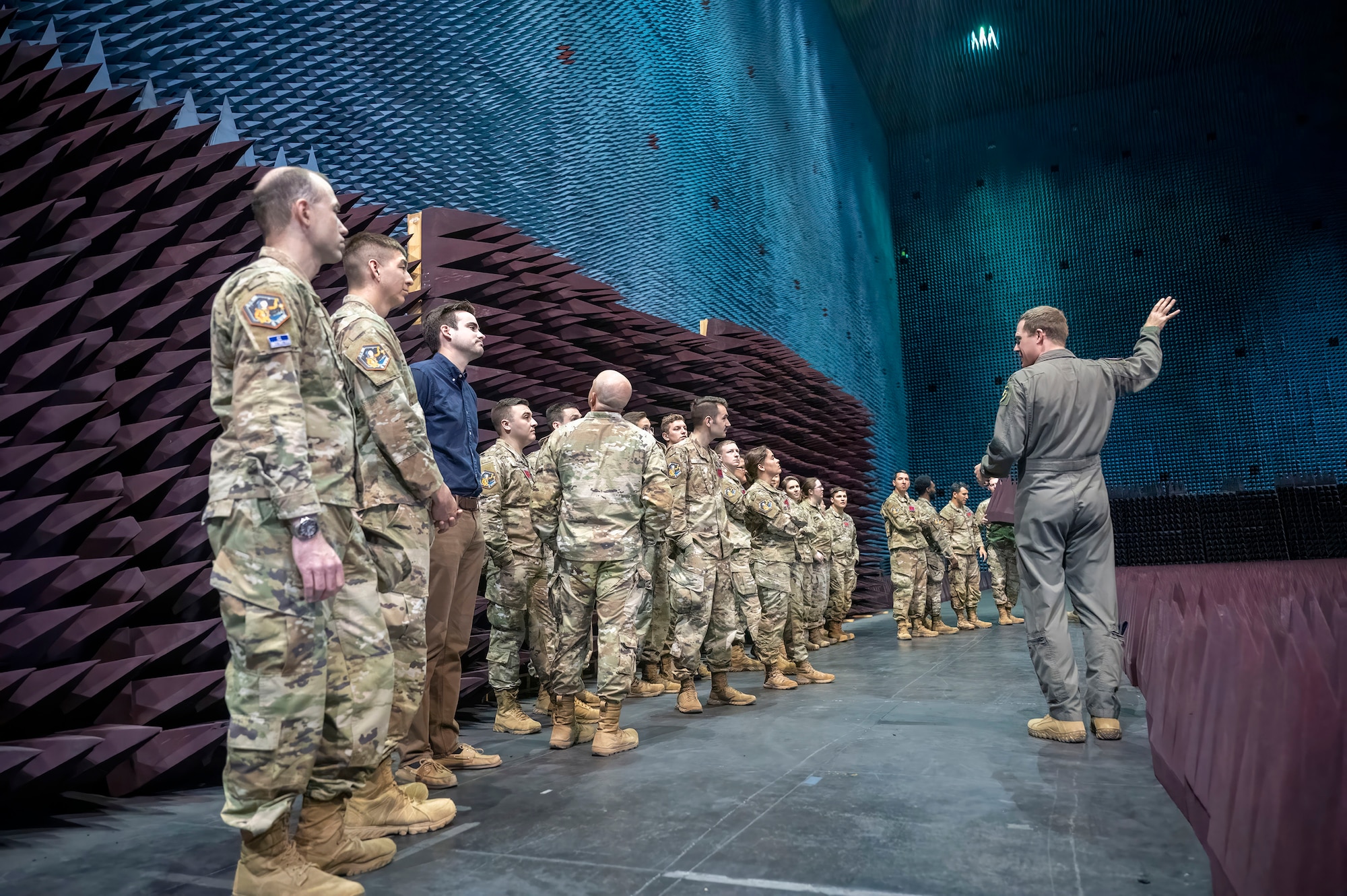 Air Force Maj. Phillip Woodhull, 772nd Test Squadron Director of Operations, provides a brief of the Benefield Anechoic Facility to Test Pilot School Space Test Course Class 23-1 students on Edwards Air Force Base, California, May 22. The STC students saw a Navigation Technology Satellite-3 (NTS-3) up close during its test campaign inside the BAF. (Air Force photo by Adam Bowles)