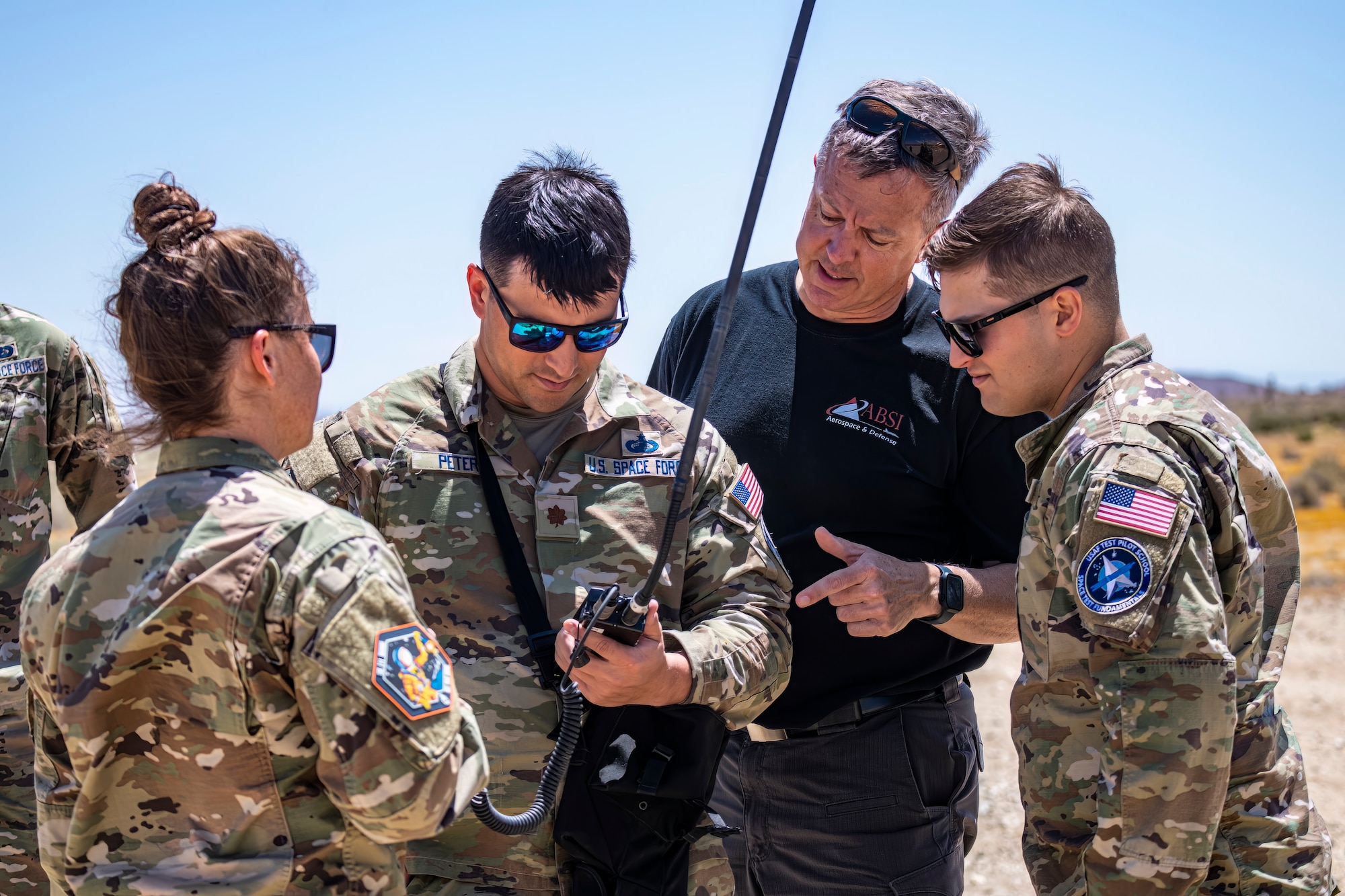 U.S. Air Force Test Pilot School Space Test Course Class 23-1 students receive instruction on radio operations at the Precision Impact Range Area on Edwards Air Force Base, California, May 10. As part of the USAFTPS STC Class 23-1 capstone project, the students utilized an HH-60W Jolly Green II helicopter to conduct simulated combat search and rescue operations using multi-domain imagery assets. (Air Force photo by Giancarlo Casem)