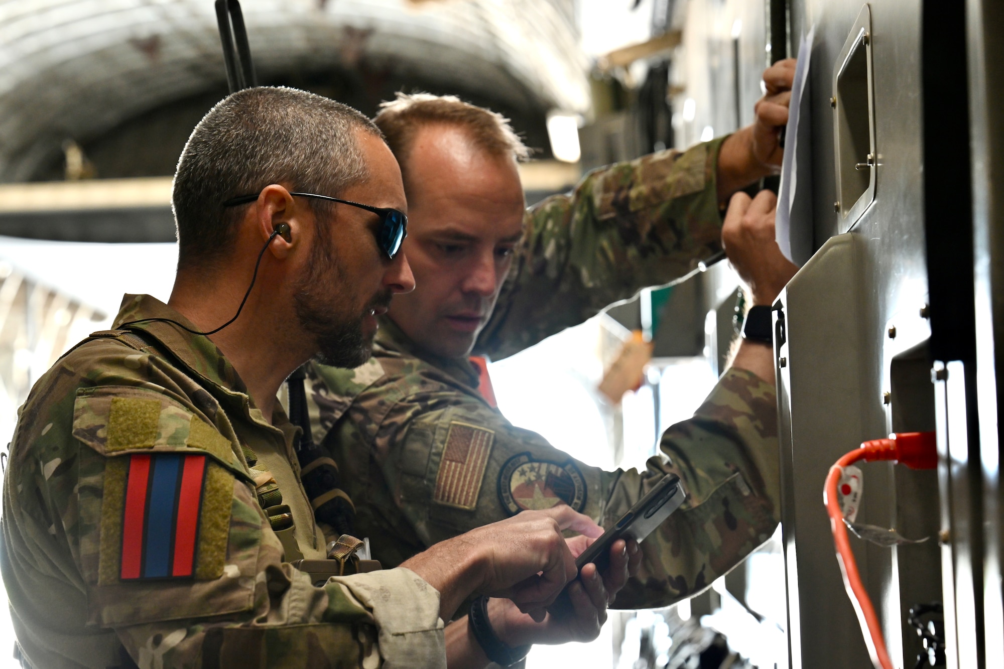 U.S. Air Force Tech. Sgt. Shawn Beedham, assigned to the 727th Air Mobility Squadron, and a pathfinder assigned to the Netherlands 11th Air Assault Brigade discuss a passenger manifest during Exercise Defender Europe 23 at Larissa Air Base, Greece, May 13, 2023.