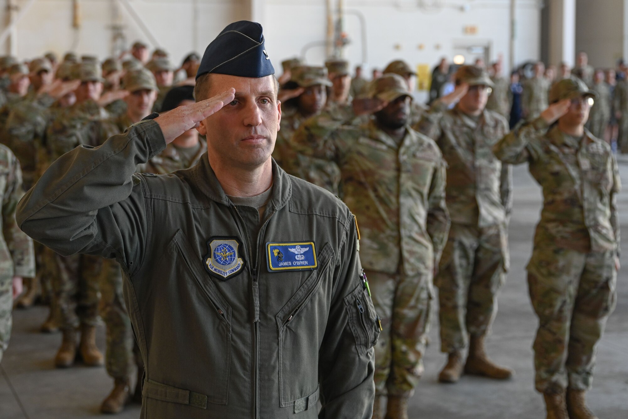 Airmen from the 19th Airlift Wing participate in a change of command ceremony in an airplane hangar