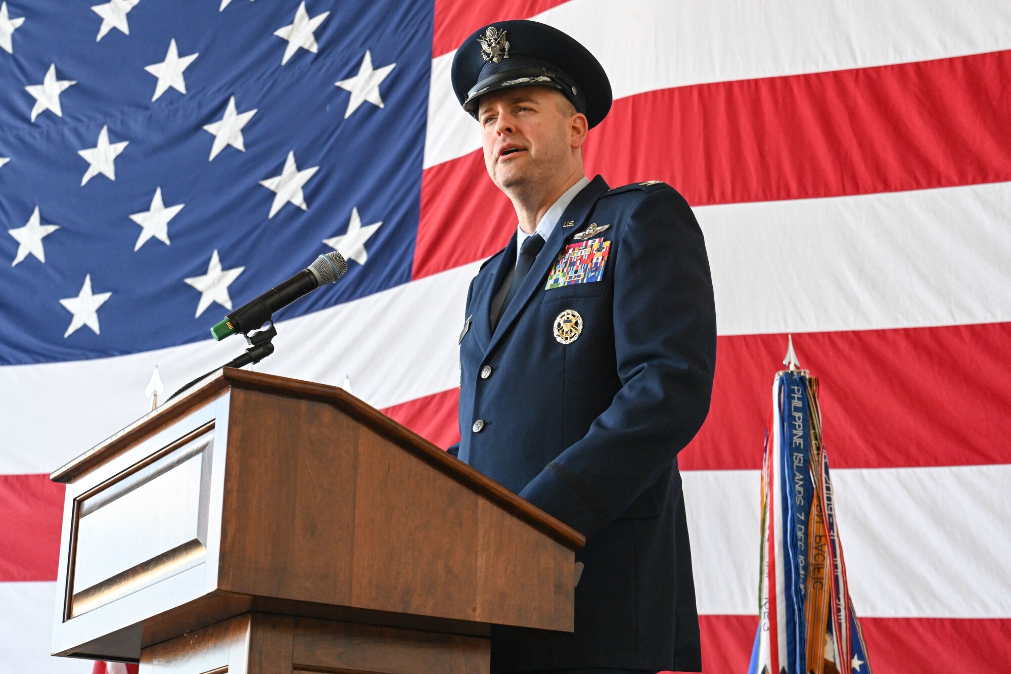 Airmen from the 19th Airlift Wing participate in a change of command ceremony in an airplane hangar