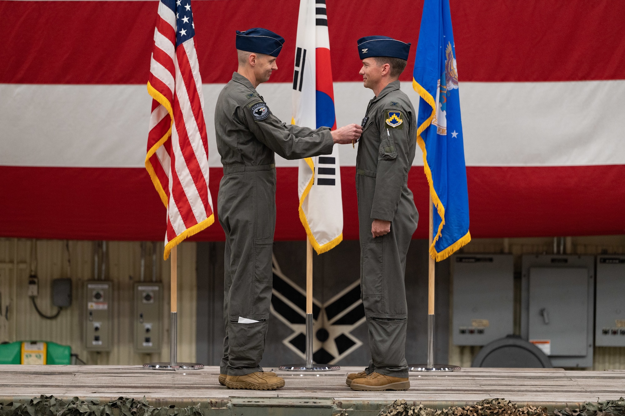 Col. Timothy B. Murphy, left, 8th Fighter Wing commander, pins a medal on Col. Matthew Belle, 8th Operations Group outgoing commander, during a change of command ceremony at Kunsan Air Base, Republic of Korea, June 2, 2023. The 8th OG commander is responsible for conventional air-to-ground and air-to-air missions in support of armistice and wartime taskings to defend the Republic of Korea. (U.S. Air Force photo by Staff Sgt. Sadie Colbert)