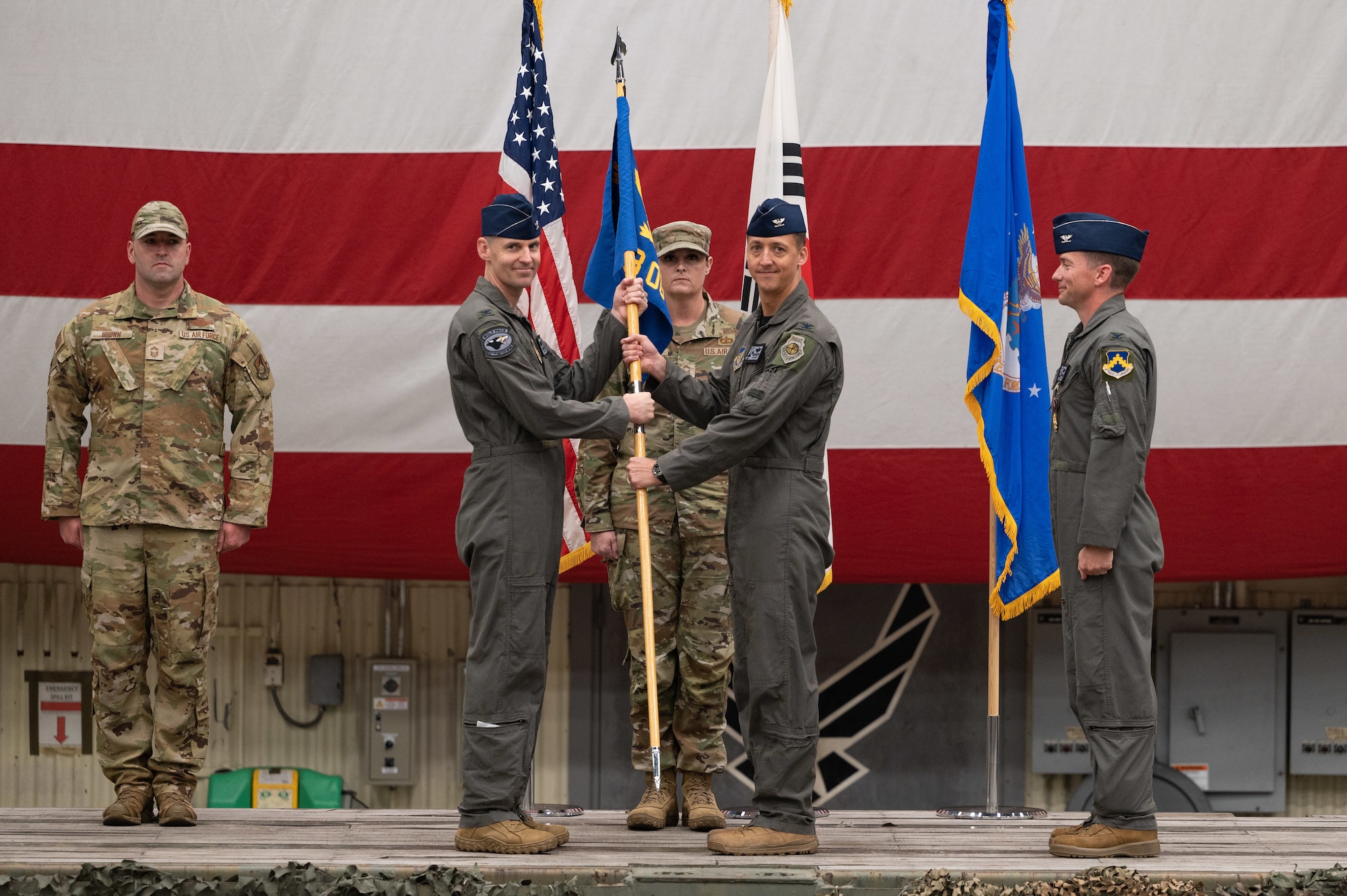 Col. Timothy B. Murphy, left, 8th Fighter Wing commander, gives a guidon to Col. Michael G. McCarthy, 8th Operations Group incoming commander, to take command of the 8th OG during a change of command ceremony at Kunsan Air Base, Republic of Korea, June 2, 2023. The 8th OG commander is responsible for conventional air-to-ground and air-to-air missions in support of armistice and wartime taskings to defend the Republic of Korea. (U.S. Air Force photo by Staff Sgt. Sadie Colbert)