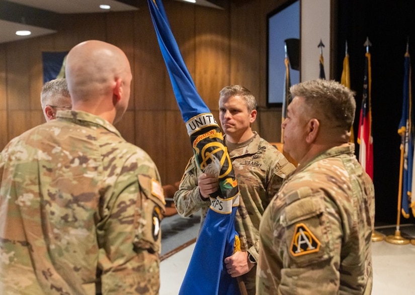 Lt. Col. Micah Rue grasps a flag during a recent consolidation ceremony at Picatinny Arsenal, New Jersey May 24, 2023, signifying his acceptance of the duty and responsibilities of the Product Manager of the newly merged Product Management Office.