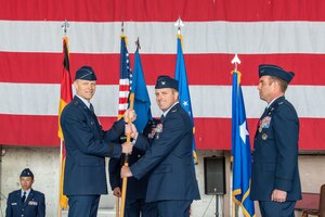 U.S. Air Force Maj. Gen. Derek France, Third Air Force commander (left), passes the guidon to Col. Kevin Crofton, 52nd Fighter Wing incoming commander