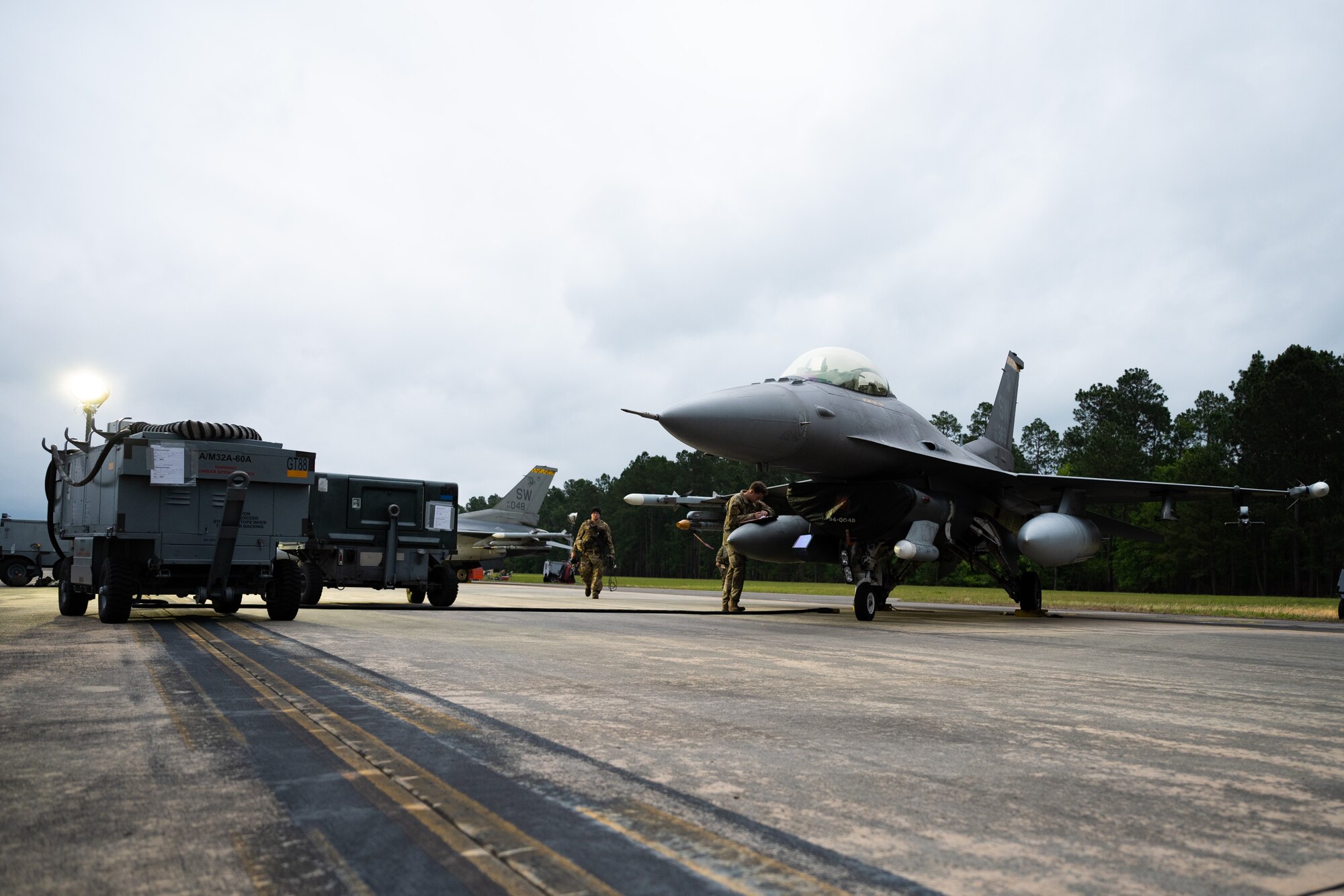 An Airman walks toward an F-16C Fighting Falcon on a makeshift flightine during a training exercise